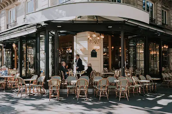 Typical view of the Parisian street with tables of brasserie (cafe) in Paris, France. Architecture and landmarks of Paris. Postcard of Paris