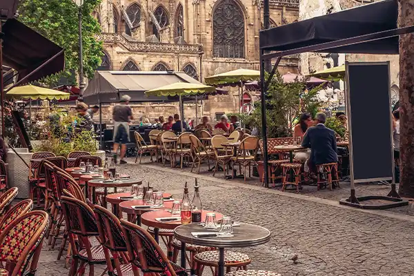 Cozy street with tables of cafe in Paris, France. Architecture and landmarks of Paris. Postcard of Paris