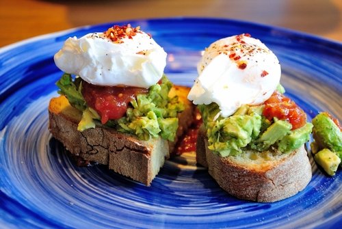 Avocado toast with poached eggs and salsa sauce, served in Newcastle, UK